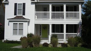 A two-story white house with a front porch, a green door, and a balcony. - In-town Lewes house with great floor plan!  112 Bradley Lane (Lewes)