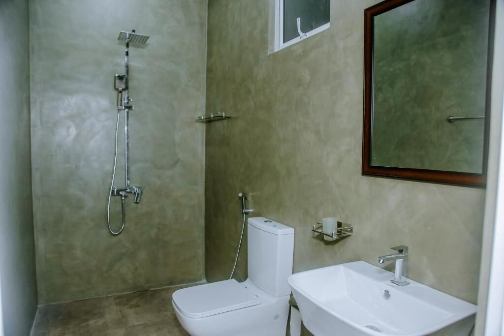 A bathroom with a shower, toilet, and sink.