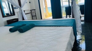 A hotel room with a bed, a view of the ocean, and a balcony with a chair. - Perfect view mirissa (Mirissa)