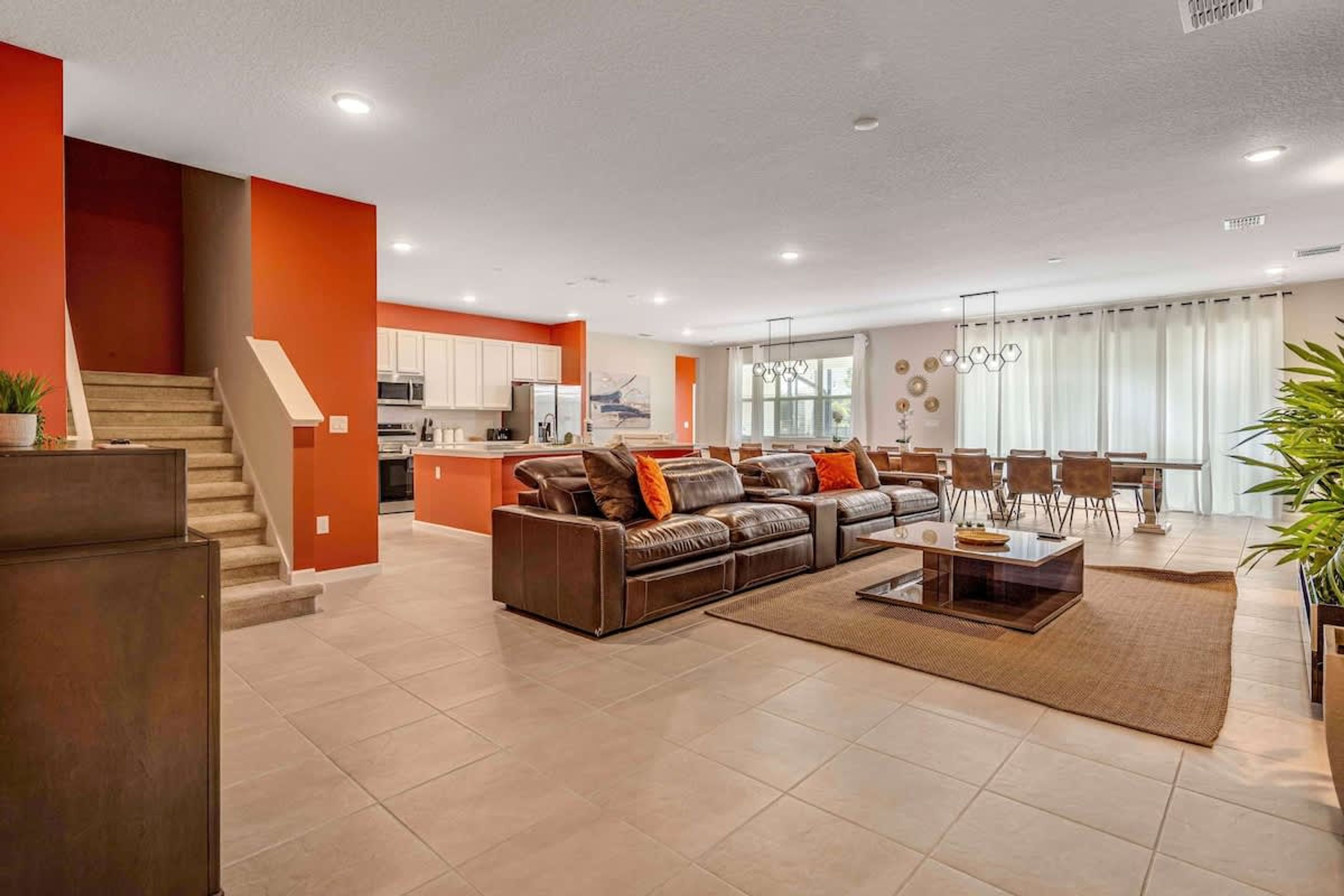 A modern living room with a sofa set, a coffee table, and a dining area with chairs.