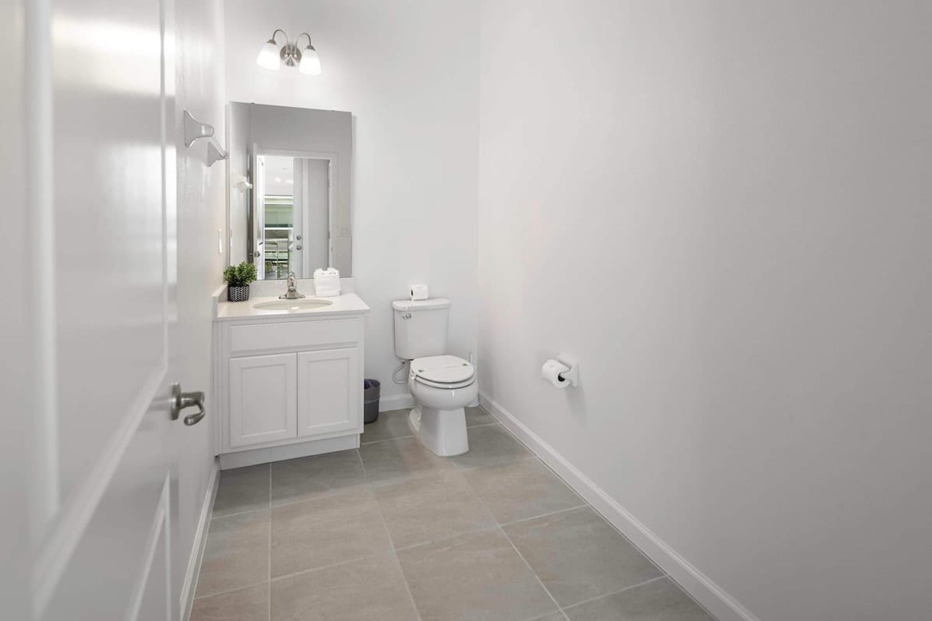 Ein modernes Badezimmer mit weißen Sanitärobjekten, einer Toilette und einem Waschbecken.
