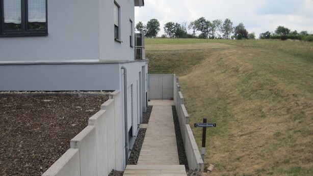 A pathway leading to a building with a sign indicating 'Ferienwohnung'.