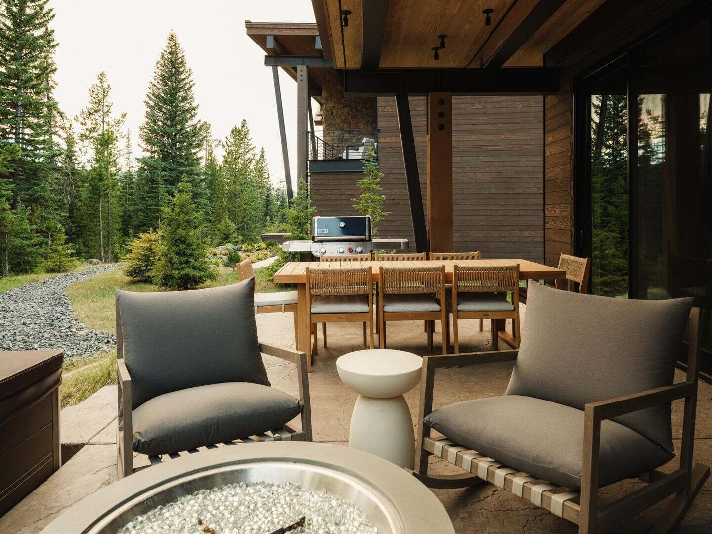 Une terrasse extérieure avec un foyer, des sièges et un barbecue.