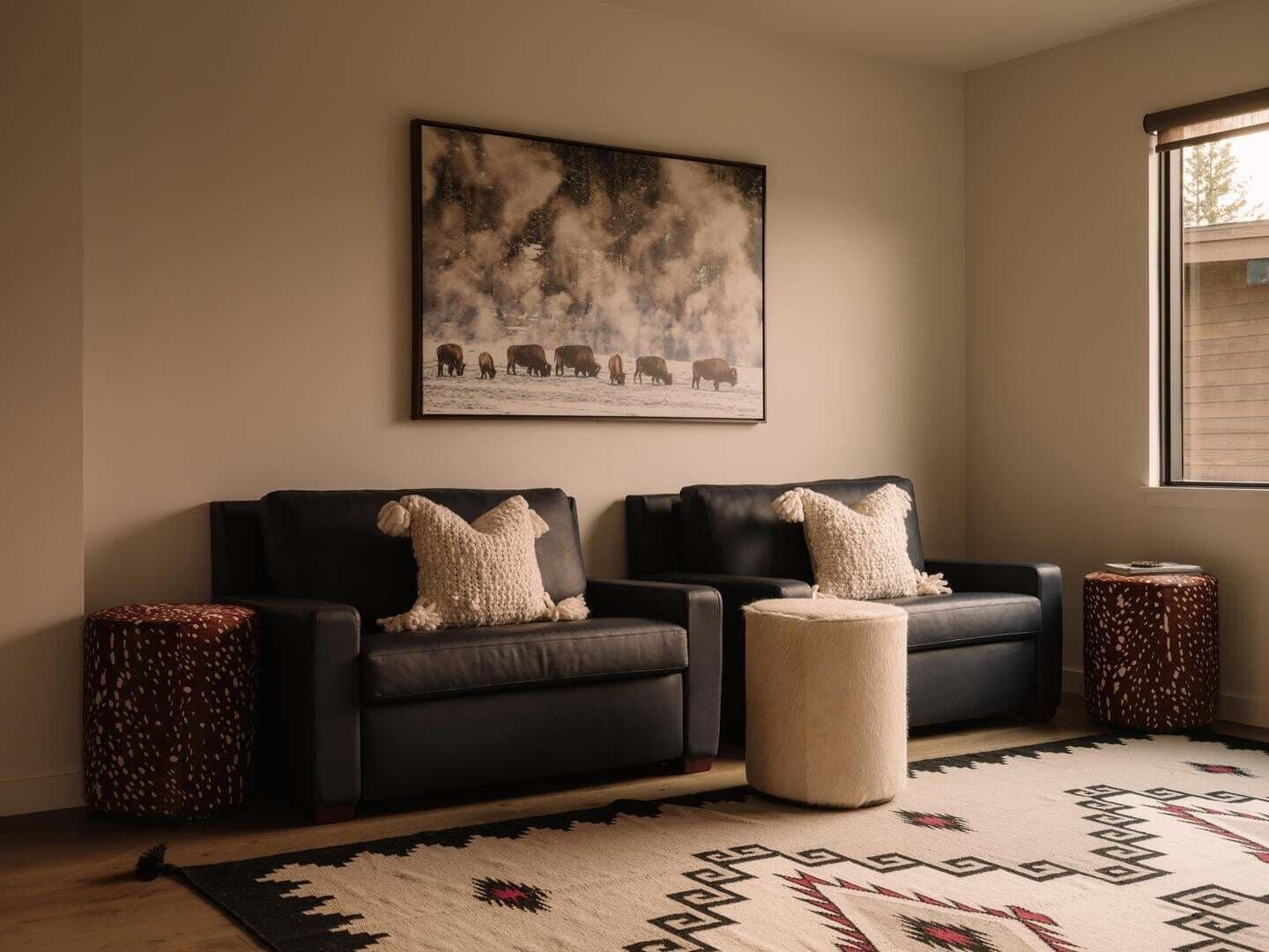A living room with a sofa set, a rug, and a painting on the wall.