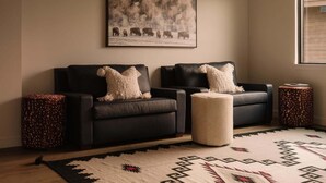 A living room with a sofa set, a rug, and a painting on the wall. - 8 Speedwell 4 Bedroom Home (Big Sky)