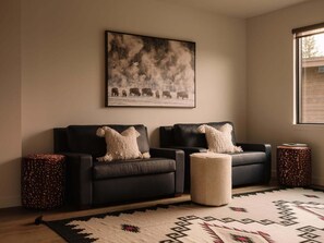 A living room with a sofa set, a rug, and a painting on the wall. - 8 Speedwell 4 Bedroom Home (Big Sky)