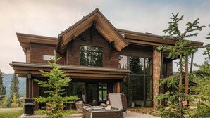 A modern two-story house with a large deck, outdoor seating, and a hot tub. - 8 Speedwell 4 Bedroom Home (Big Sky)