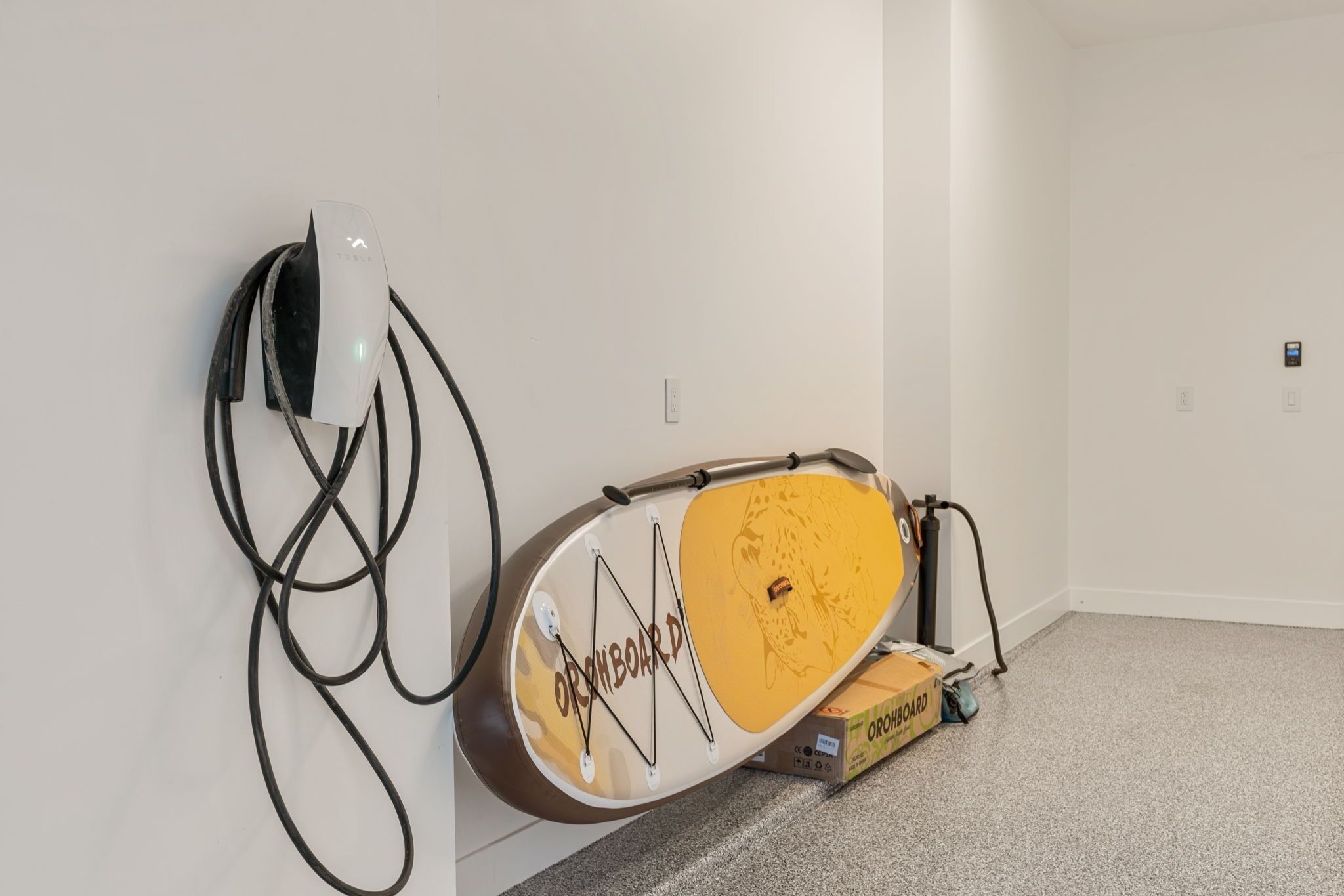 A white wall with a white device and a yellow object with 'ORCHIBOARD' text.