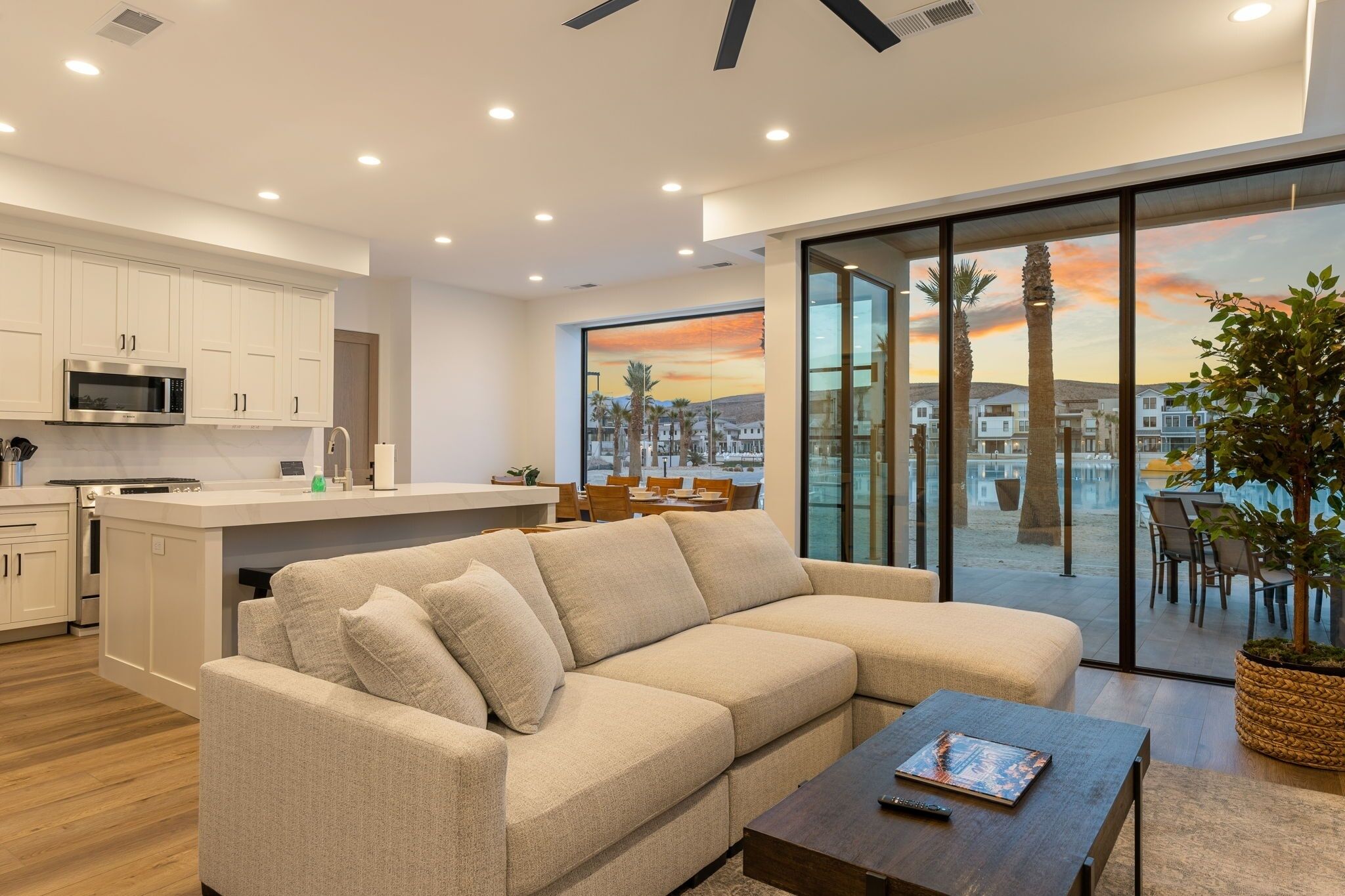 A modern living area with a sofa, coffee table, and a view of a cityscape through large windows.