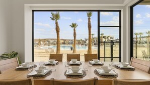 A dining area with a view of a pool and palm trees. - Pearl Beach A 3 Bedroom Townhouse (St. George)