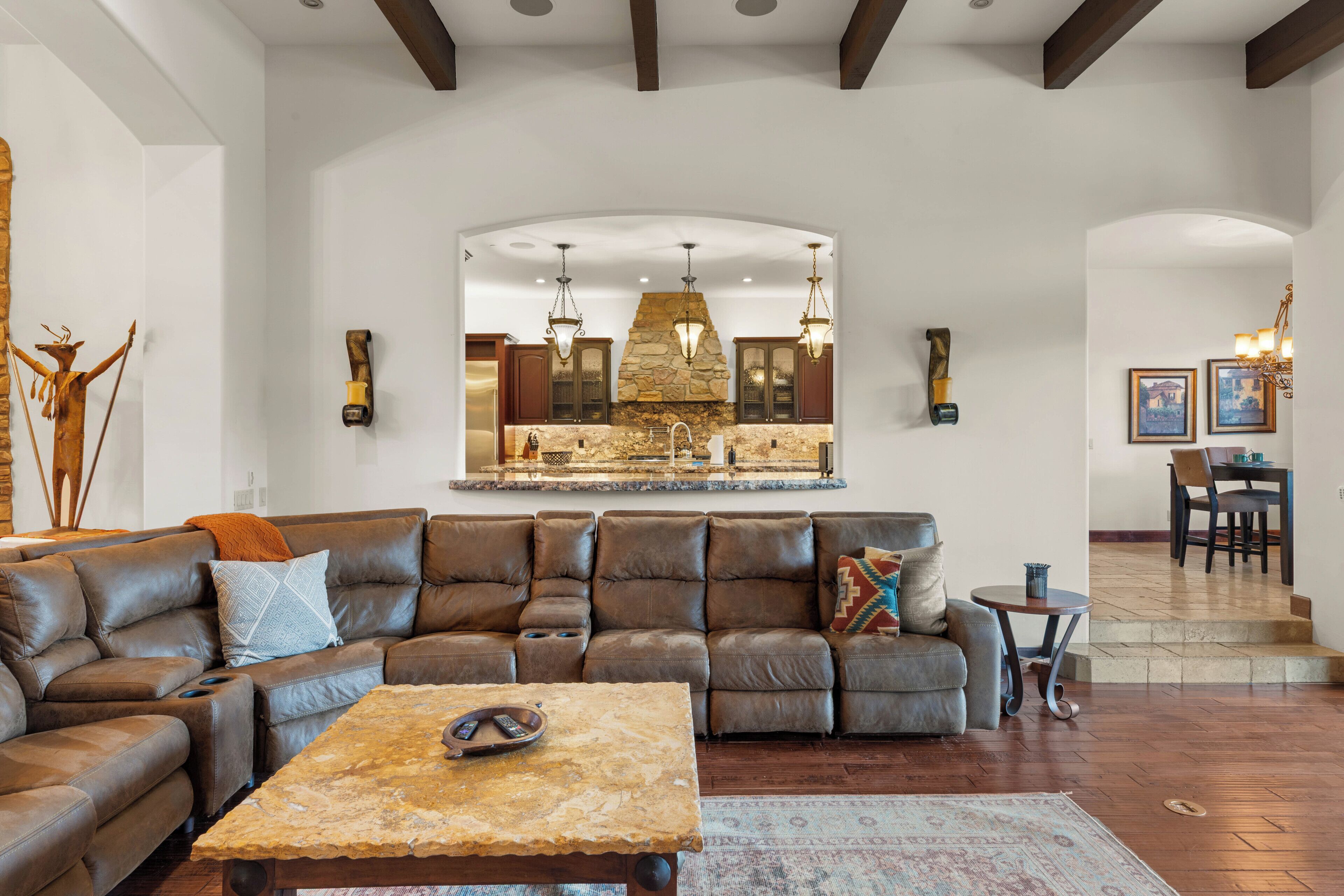 A living room with a sectional sofa, a coffee table, and a fireplace.