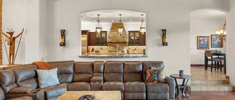 A living room with a sectional sofa, a coffee table, and a fireplace.