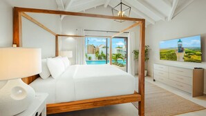 Ein modernes Schlafzimmer mit einem Himmelbett, einem Fernseher und Blick auf einen Swimmingpool.
