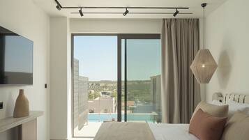 Un dormitorio moderno con una cama grande, un televisor de pantalla plana, vista a una piscina y un balcón.