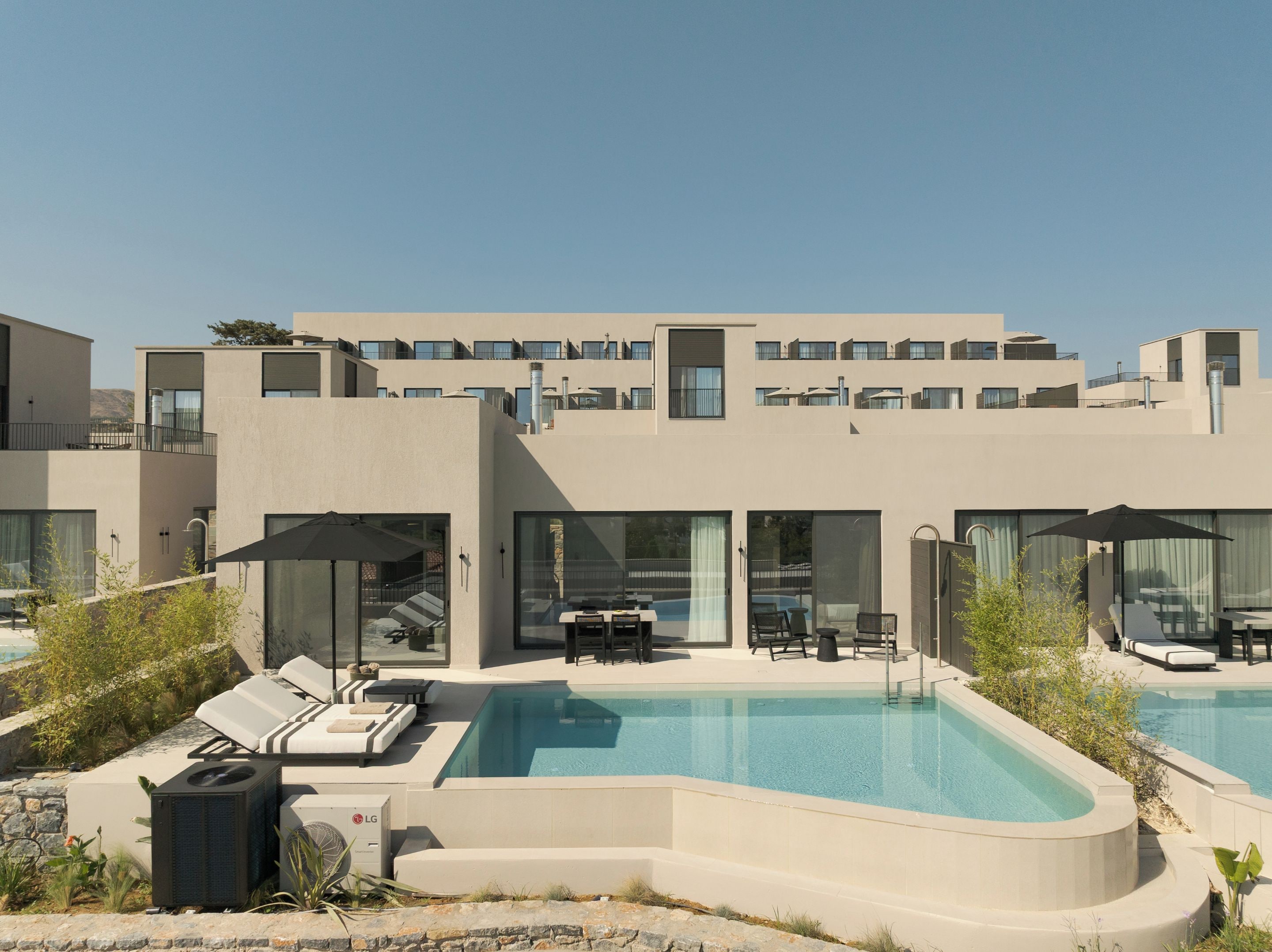Ett modernt hotell med en swimmingpool, utomhusplats och en vacker utsikt över det omgivande landskapet.