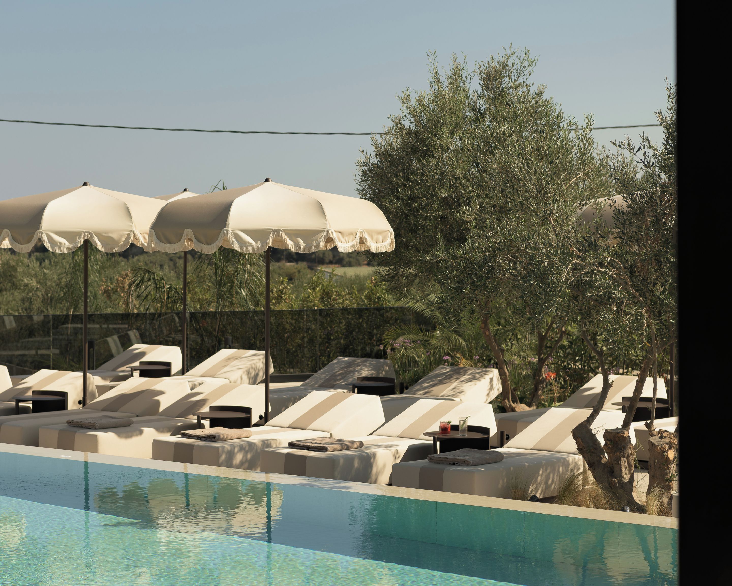 A poolside area with lounge chairs and umbrellas.