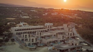 Un hôtel moderne composé de plusieurs bâtiments, doté d’une piscine et offrant une vue sur le paysage environnant.
