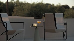 Two lounge chairs with towels, a small table, and a glass of drink on a terrace. - Neme Slow Living Retreat (Rethymno)