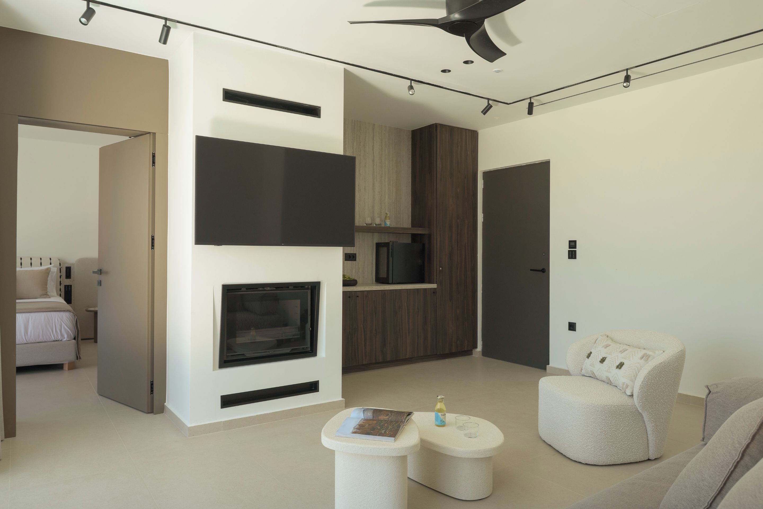 Ein modernes Wohnzimmer mit Kamin, einer Couch, einem Couchtisch und einem Fernseher.