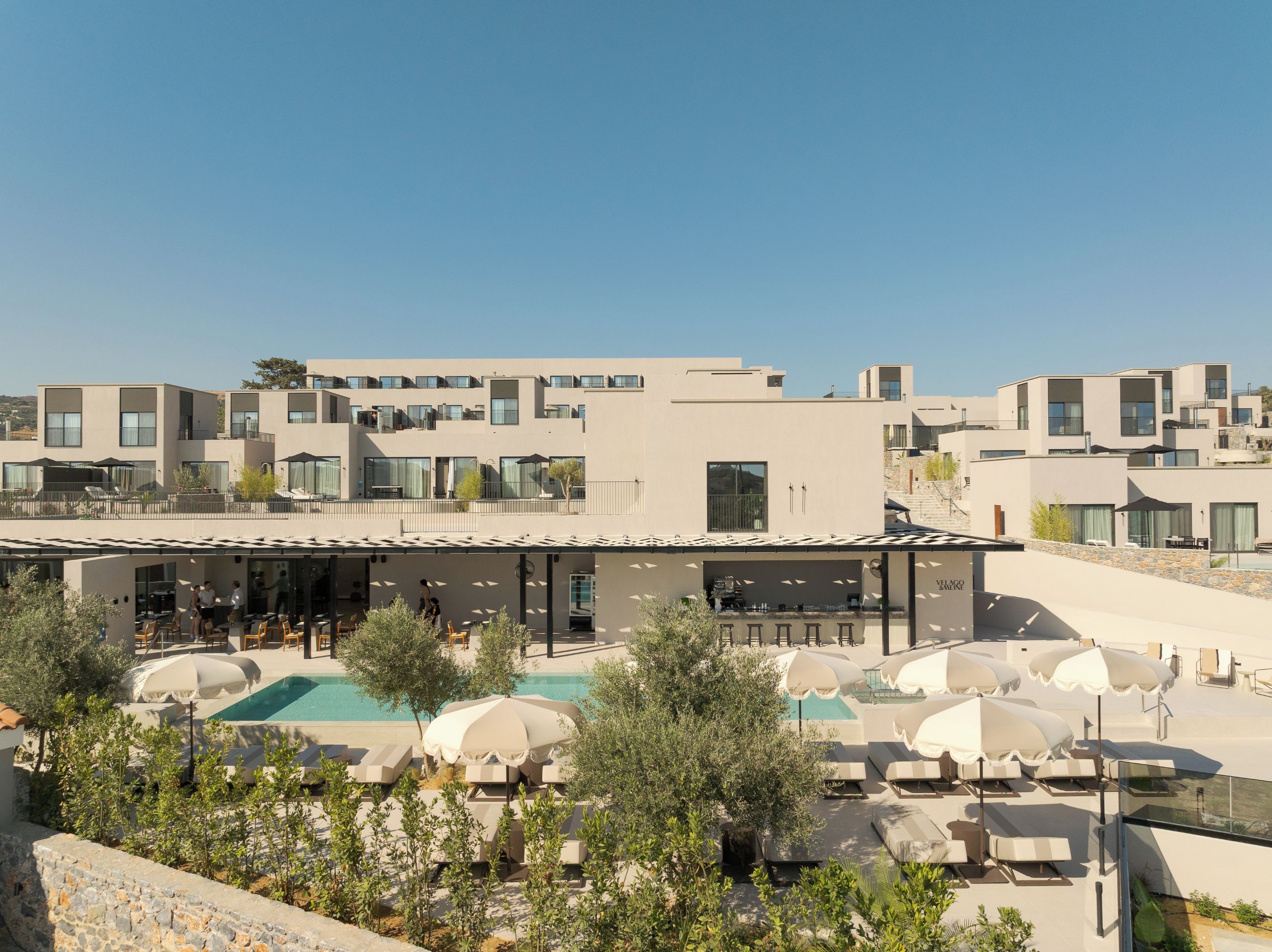 Un hôtel moderne doté d’une piscine sur le toit, d’un espace extérieur aménagé et offrant une vue dégagée sur le paysage environnant.