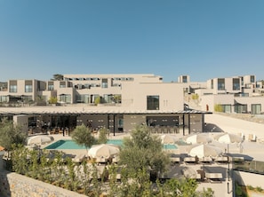 Un hôtel moderne doté d’une piscine sur le toit, d’un espace extérieur aménagé et offrant une vue dégagée sur le paysage environnant.