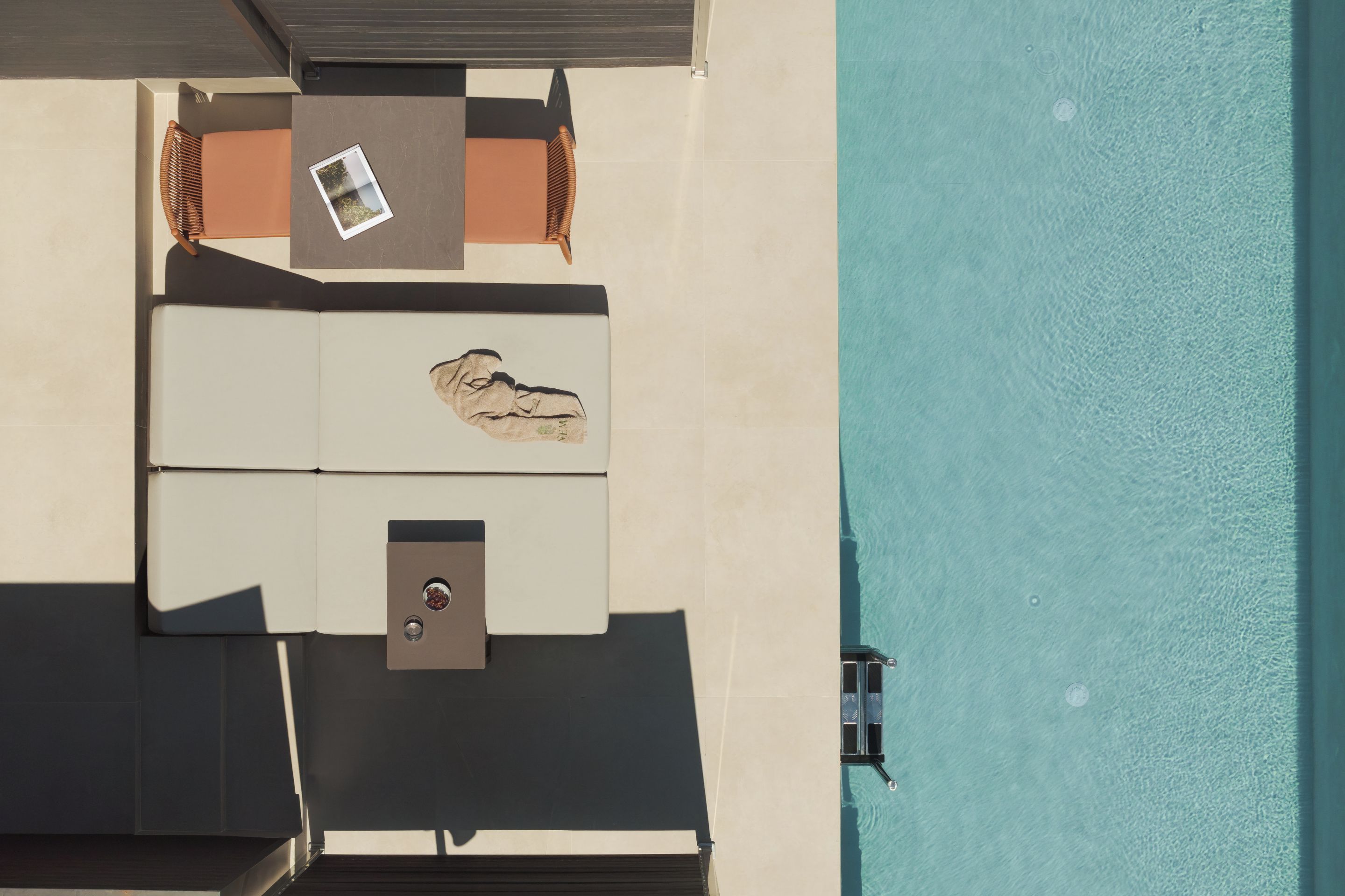 Vista aérea de una terraza en la azotea con piscina, una mesa y sillones de descanso.