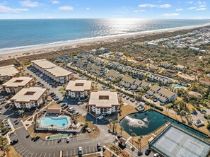 An aerial view of a coastal resort with multiple buildings, a swimming pool, and a tennis court. - Tidal Terrace l Heated Pool l Steps to Beach! (St. Augustine)