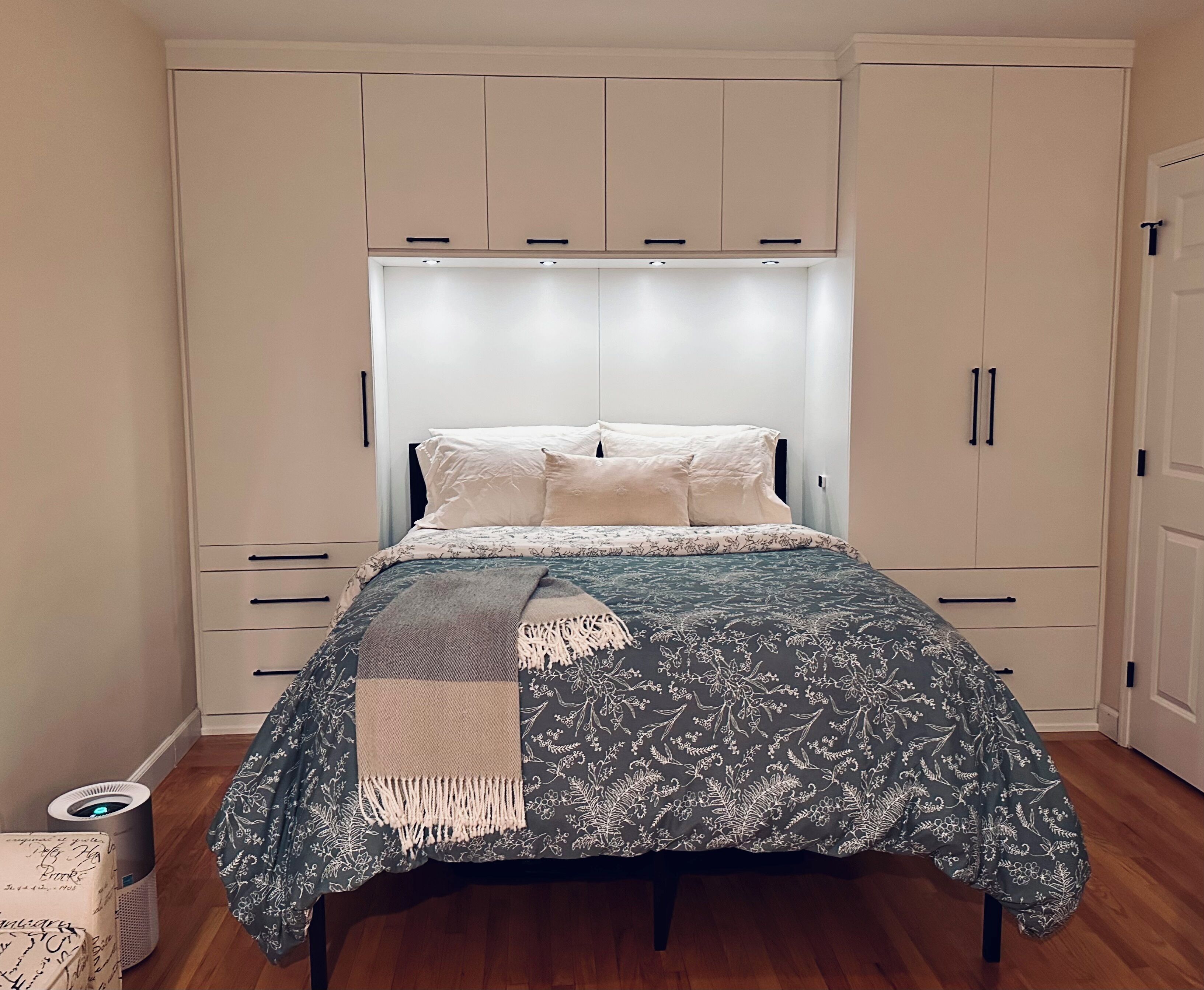 A bedroom with a bed, a wardrobe, and a bedside table.