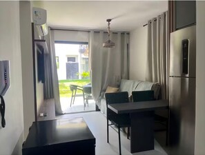 A compact kitchen with a dining area, a built-in oven, and a refrigerator.