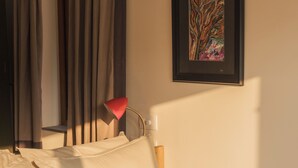 A neatly made bed with white linens, a red lamp, and a framed abstract painting on the wall. - Flor De Lis - 4 BHK Villa w/Pool, wifi & parking behind Sakana in Anjuna (Vagator)