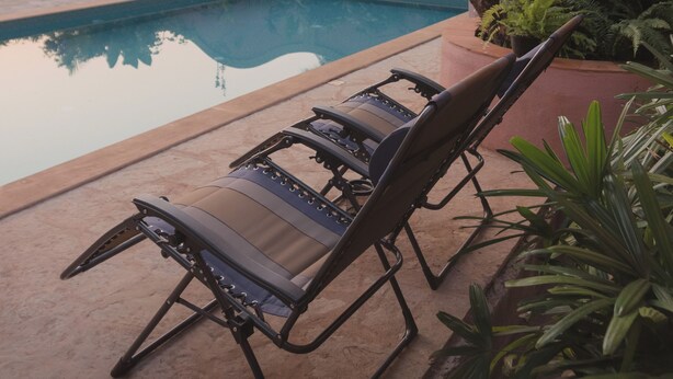 A poolside area with lounge chairs and a large tree. - Flor De Lis - 4 BHK Villa w/Pool, wifi & parking behind Sakana in Anjuna (Vagator)