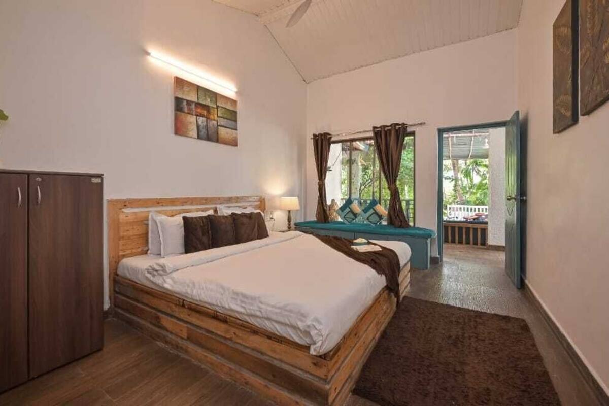 Un dormitorio con una cama de madera, un armario y vistas al exterior a través de una ventana.