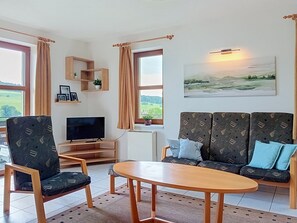 A living room with a sofa, a TV, a coffee table, and a painting on the wall. - Green Valley Park Stárkov 21 by Interhome (Stárkov)