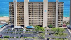 Ein mehrstöckiges Hotel mit Parkplatz und Blick auf den Ozean.