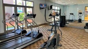 Kuntosali, jossa on juoksumattoja ja crosstrainer-laitteita.