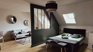 Quarto moderno com cama, um banco e vista para o exterior.