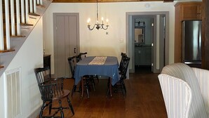 Un espace repas doté d’un plafond en bois, d’un lustre et d’une table à manger avec des chaises.
