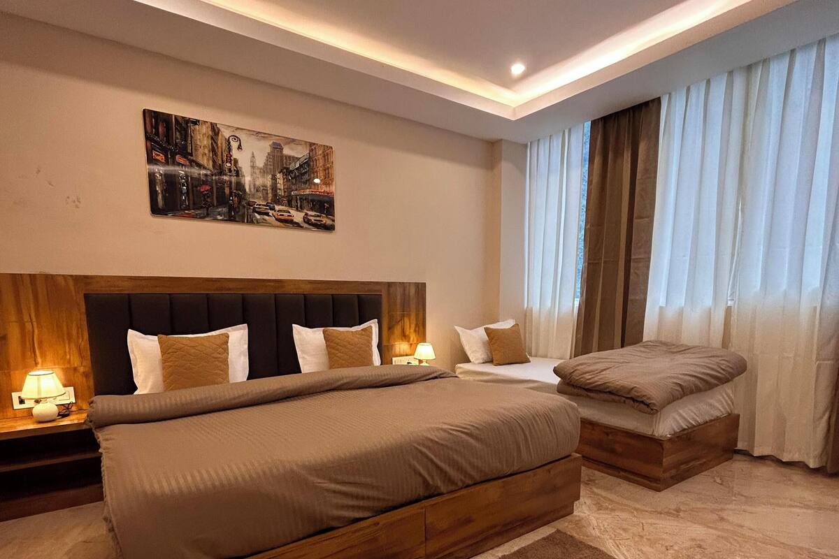 Un dormitorio moderno con una cama grande, un ventilador de techo y un cuadro de un paisaje urbano en la pared.