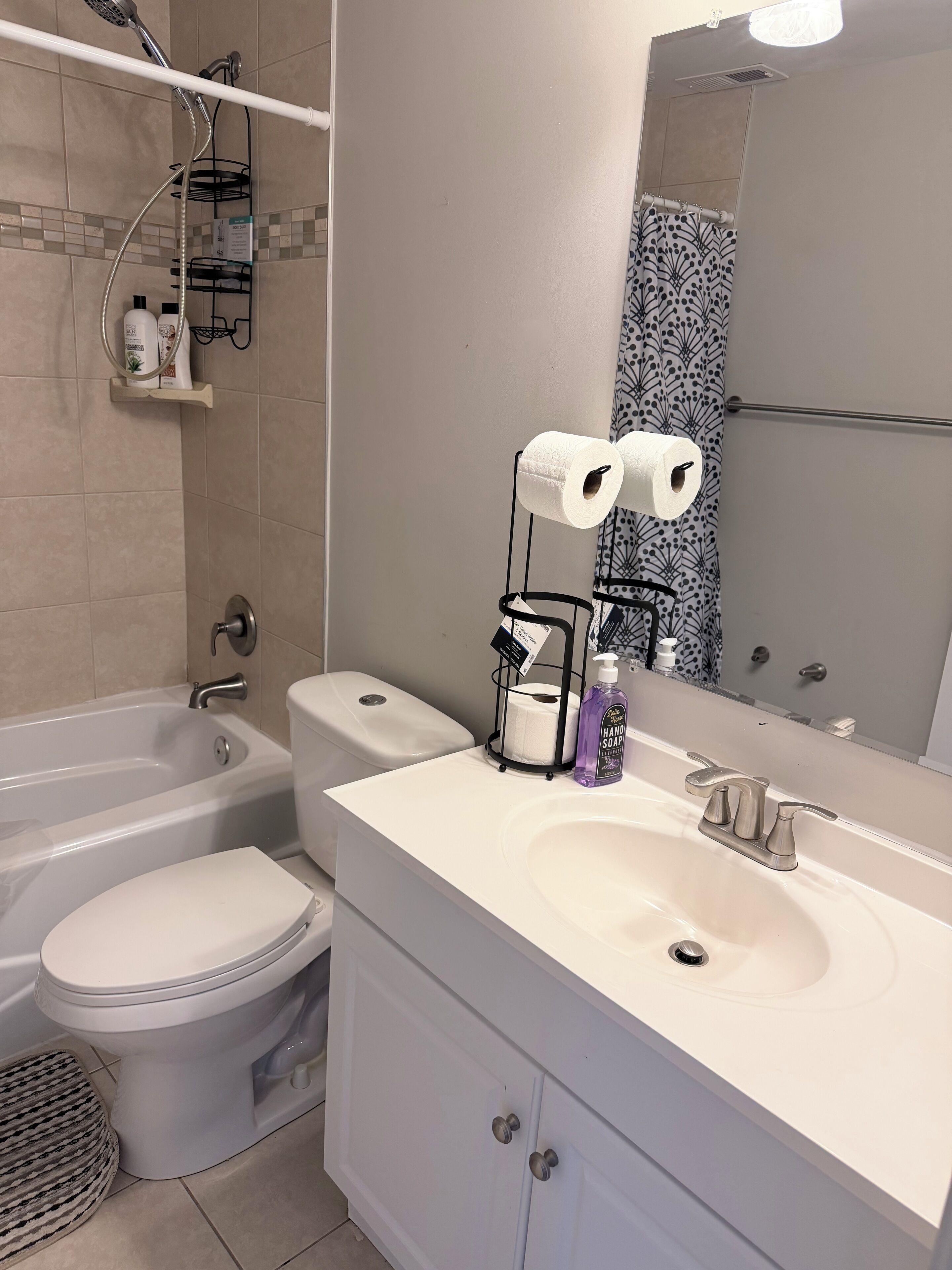 A modern bathroom with a bathtub, toilet, and sink.