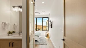 A modern bathroom with a large mirror, sink, and towel rack. - Pearl Beach B: Lagoon Front + Beach Access (St. George)