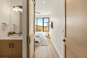 A modern bathroom with a large mirror, sink, and towel rack. - Pearl Beach B: Lagoon Front + Beach Access (St. George)