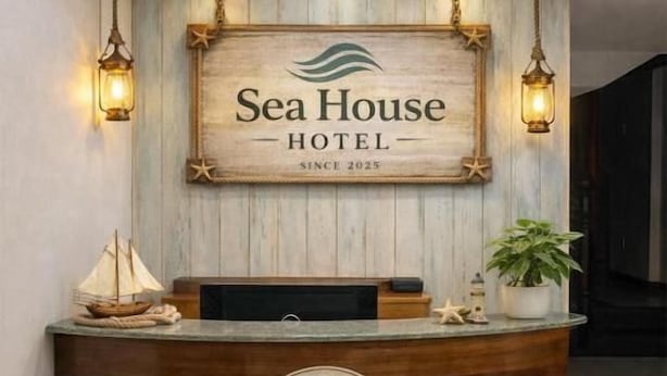 Una recepción con detalles de madera y un cartel que dice "Sea House Hotel Desde 2025".
