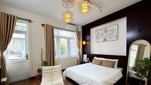 Un dormitorio con una cama grande, una mesita de noche, un espejo y una ventana con cortinas.