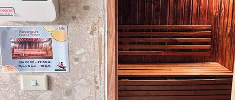 A sauna room with wooden benches and a control panel for the sauna heater.