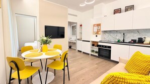Une cuisine moderne avec des armoires blanches, une cuisinière noire et un dosseret en marbre.