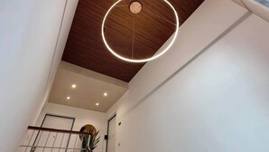 Un intérieur moderne avec un plafond en bois, un éclairage encastré et un luminaire circulaire.