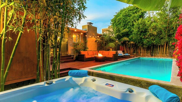 A hot tub with a blue towel, a pool, outdoor furniture, and bamboo plants. - Perfect for Families W/ Pool,Walk 2 Beach,Firepit! (San Diego)