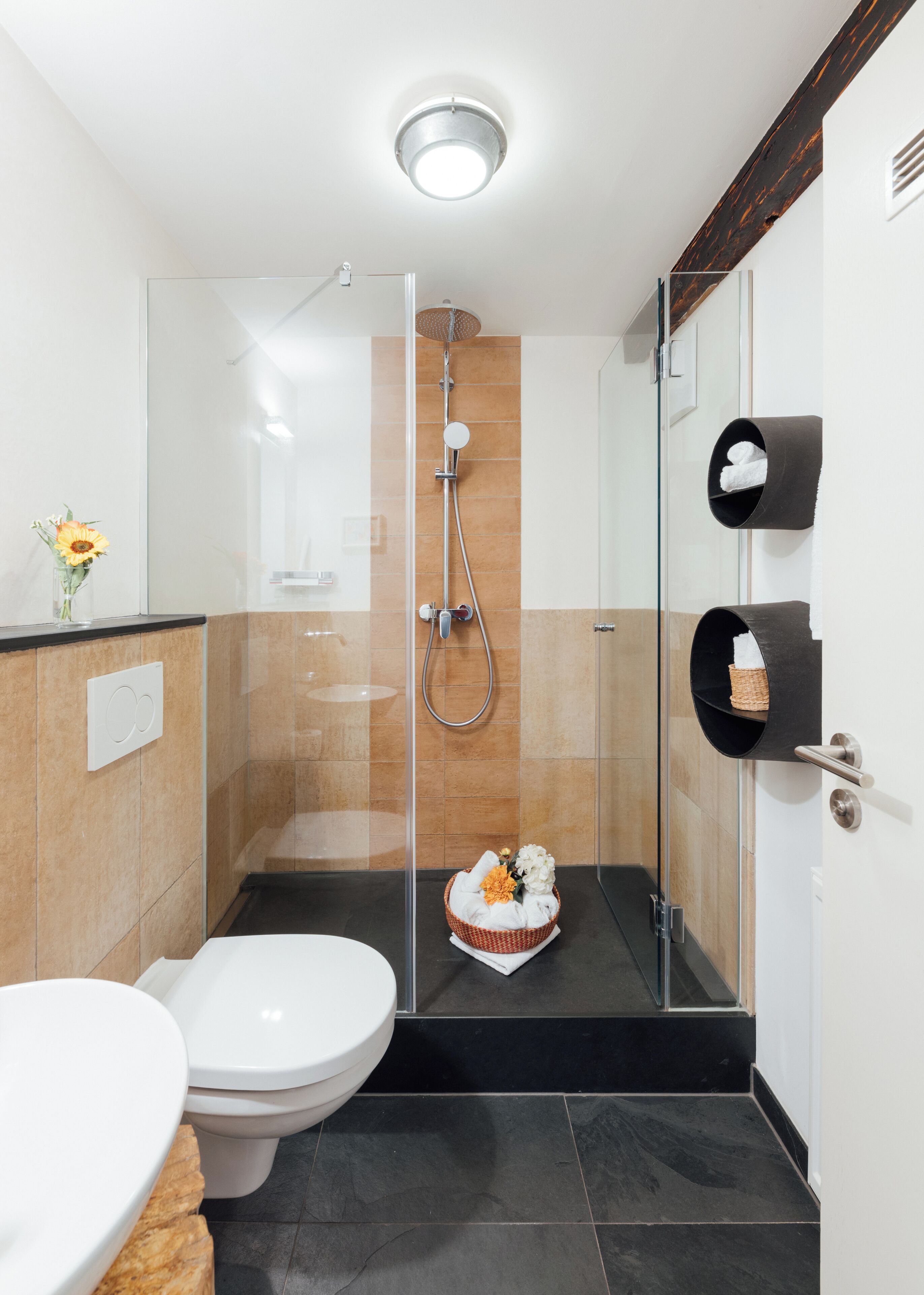 A modern bathroom with a glass-enclosed shower, a toilet, and a sink.