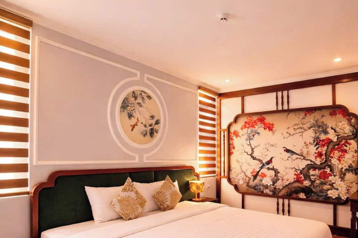 Una cama grande con cabecera de madera, una obra de arte colgada en la pared y una lámpara en el techo.