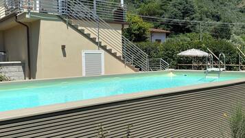 Une piscine dotée d’un espace couvert, d’un escalier et offrant une vue sur une montagne.